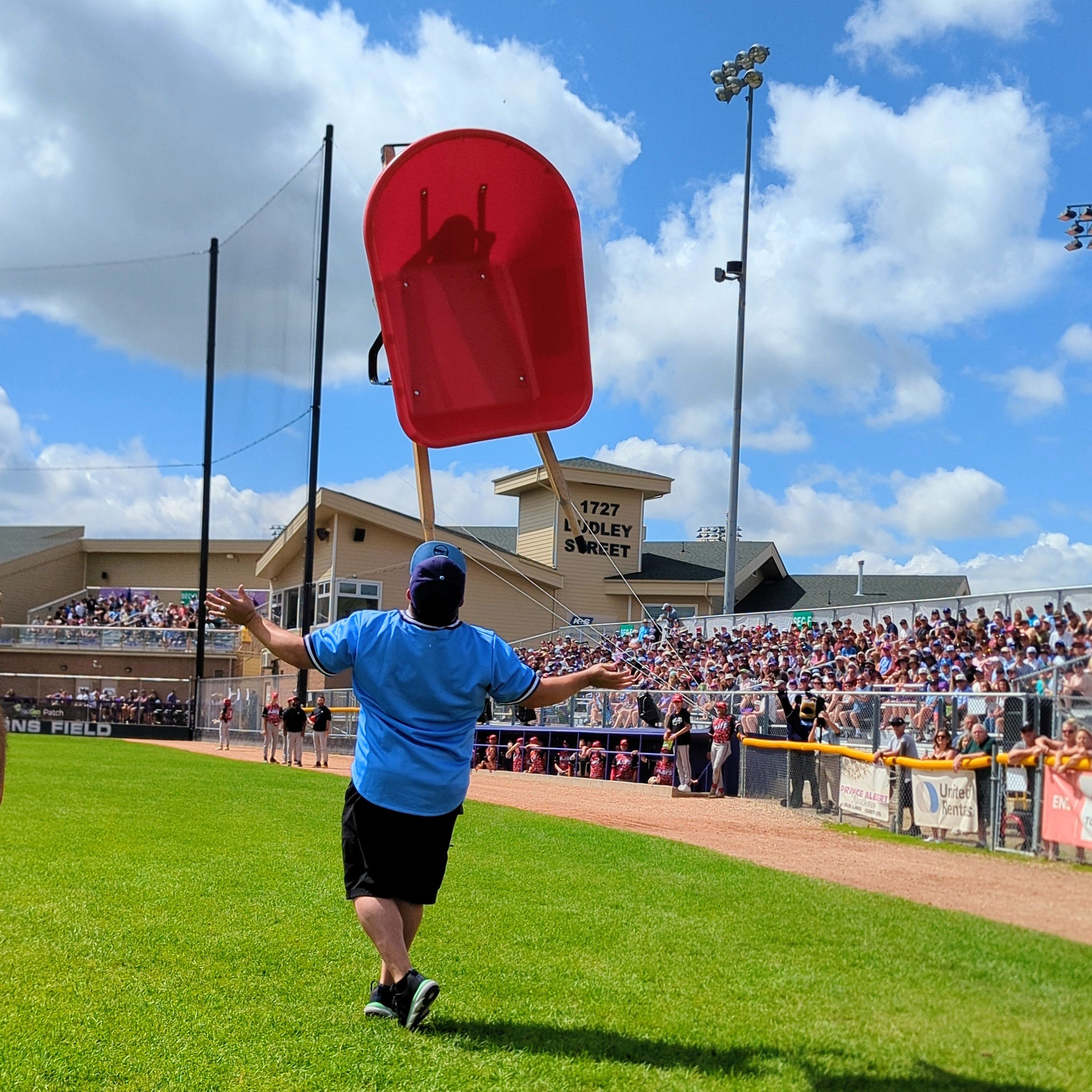 Professional chin balancer Kevin Shiflett balancing red chair at outdoor stadium performance